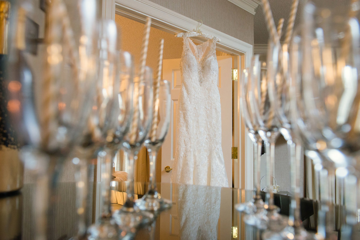 Champagne glasses and bride's dress hanging at The Inn at Fox Hollow