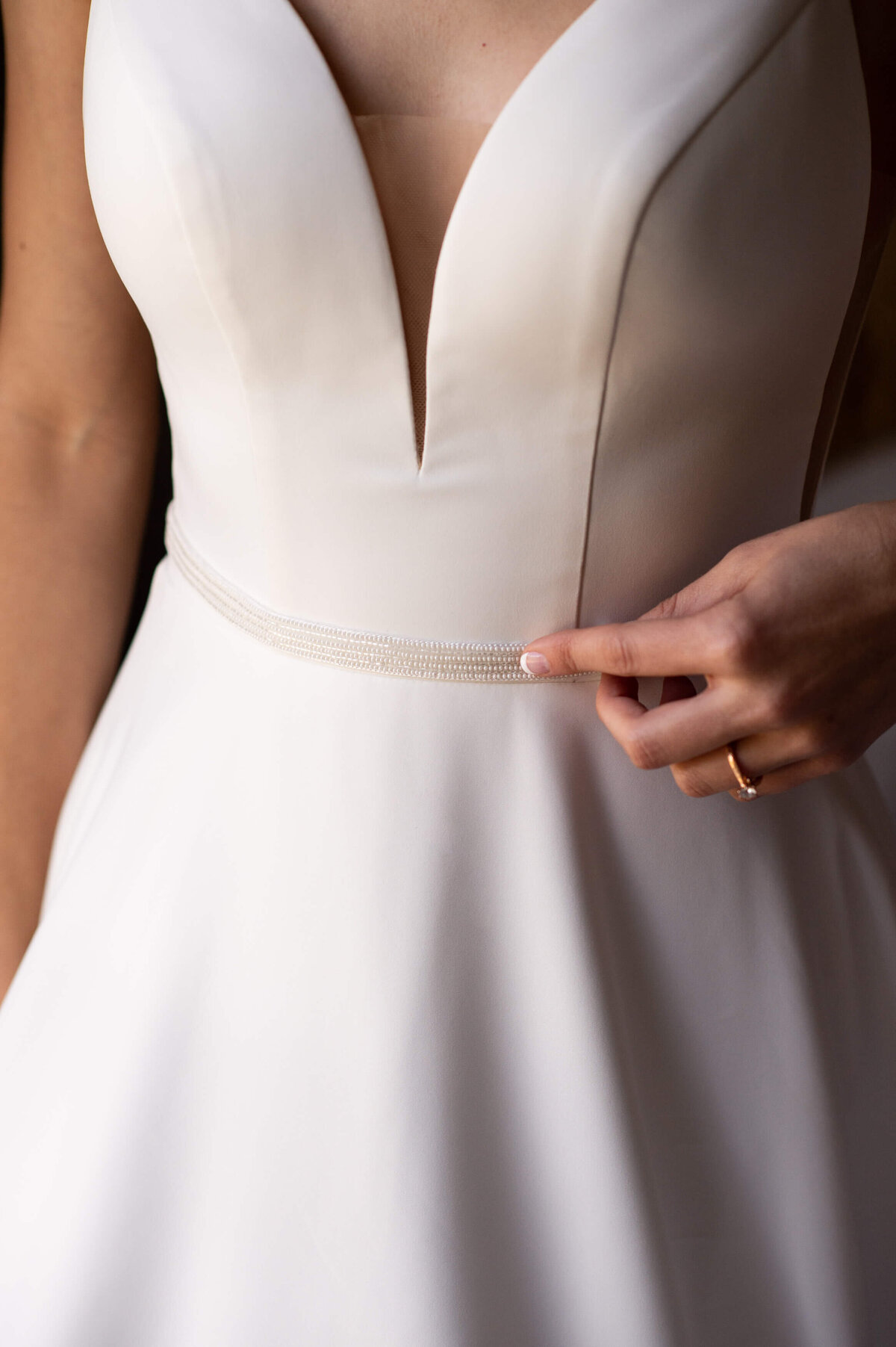 closeup of dainty pearl details of a wedding dress belt popular for Ottawa weddings