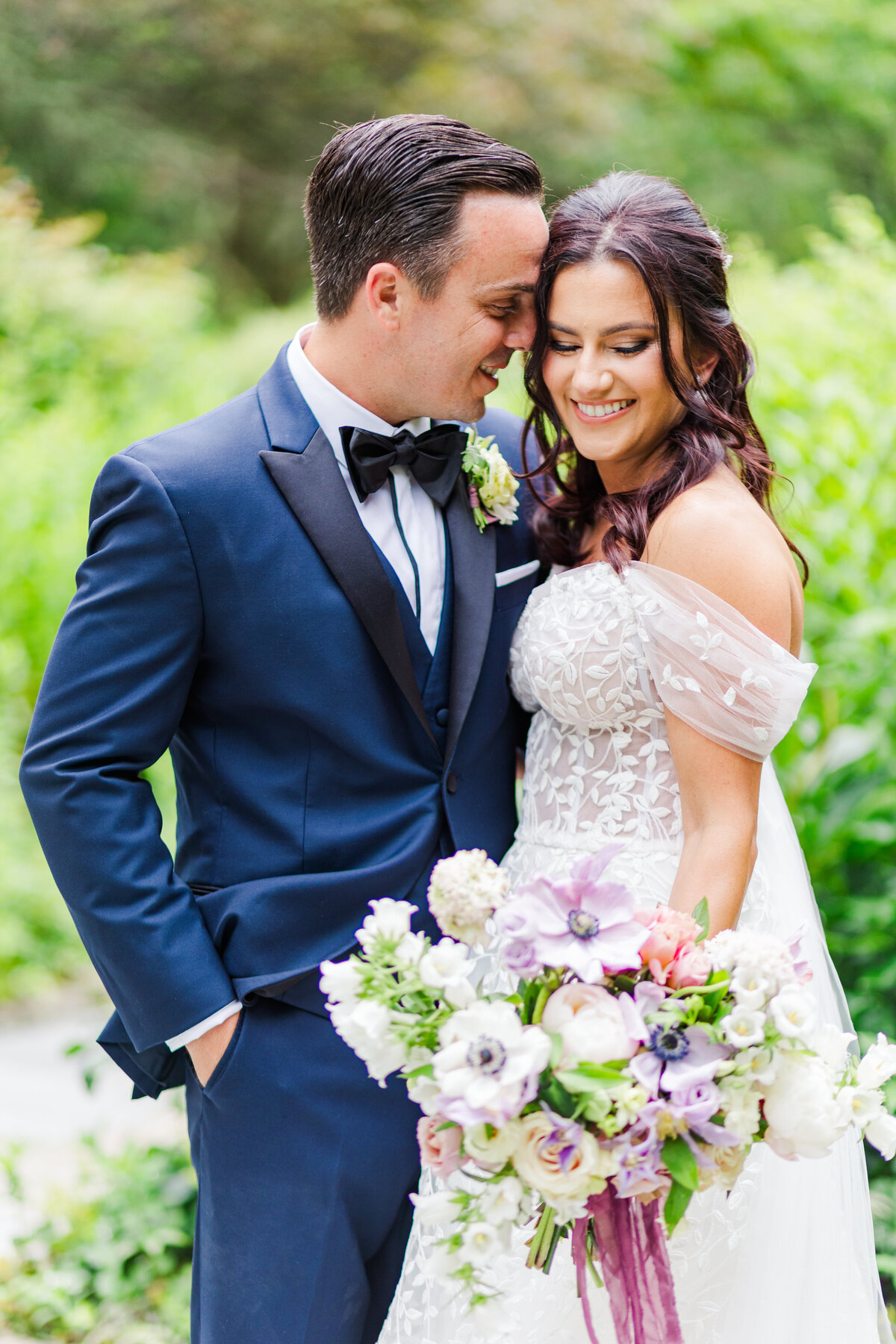 stunning bride and groom with gorgeous purple spring floral bouquet