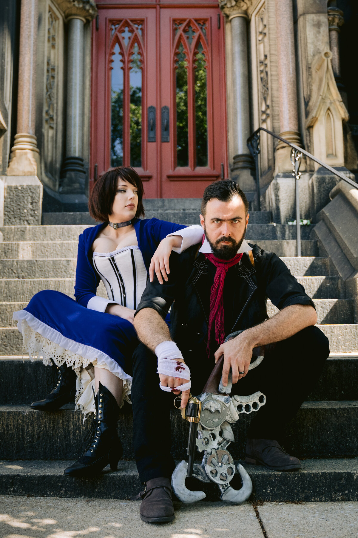 A couple dressed up in cosplay sitting on a staircase.