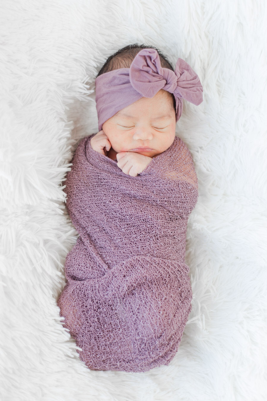 Newborn swaddled in purple and sleeping in Johnstown, CO