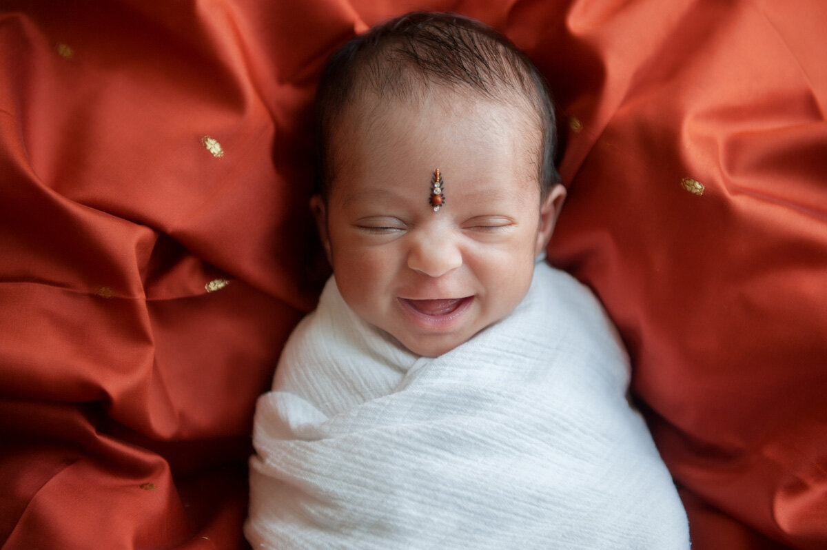 Newborn session of baby on top of red sheet