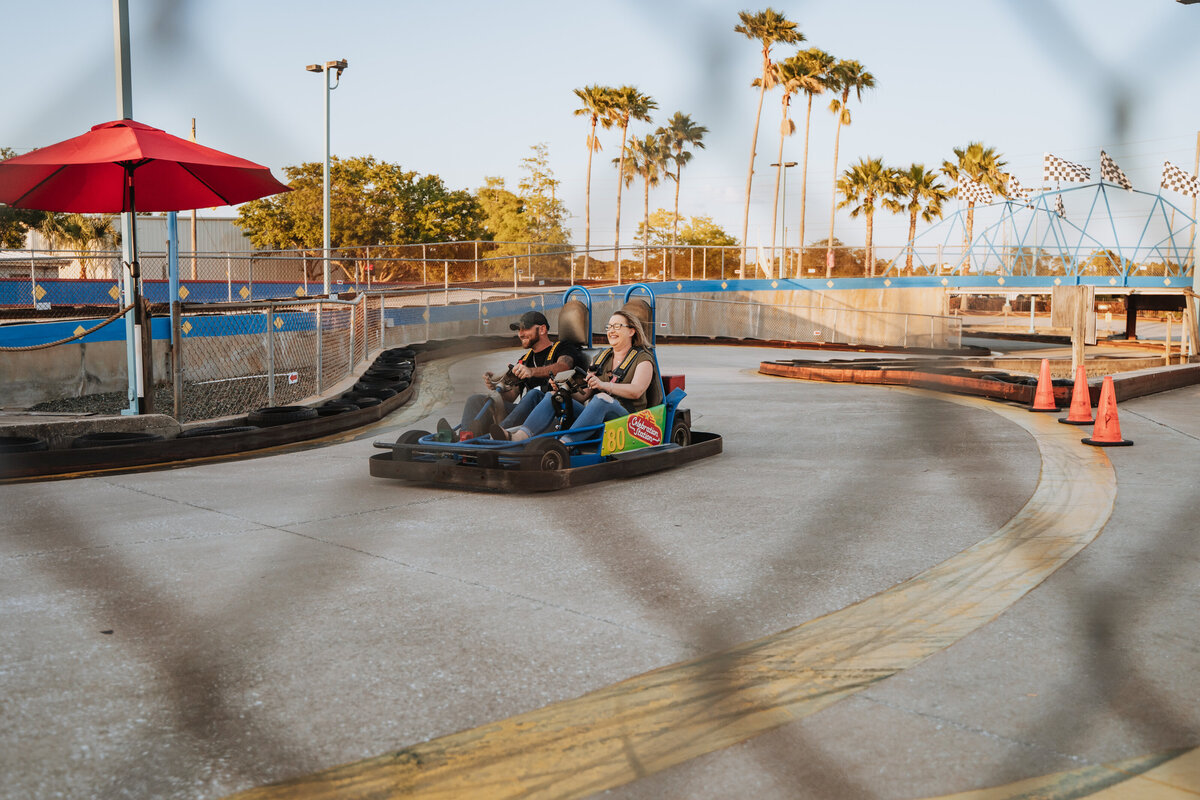 couple racing go karts during engagement session