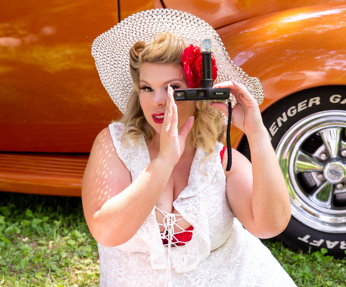 goddess studio boudoir woman taking picture with vintage camera red flower beach hat white dress red bra old ford pickup