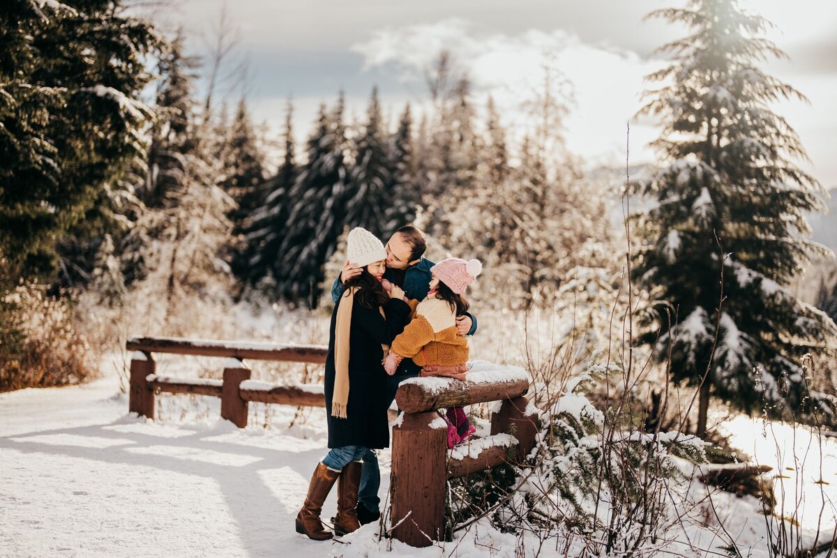 family-of-three-playing-in-snow