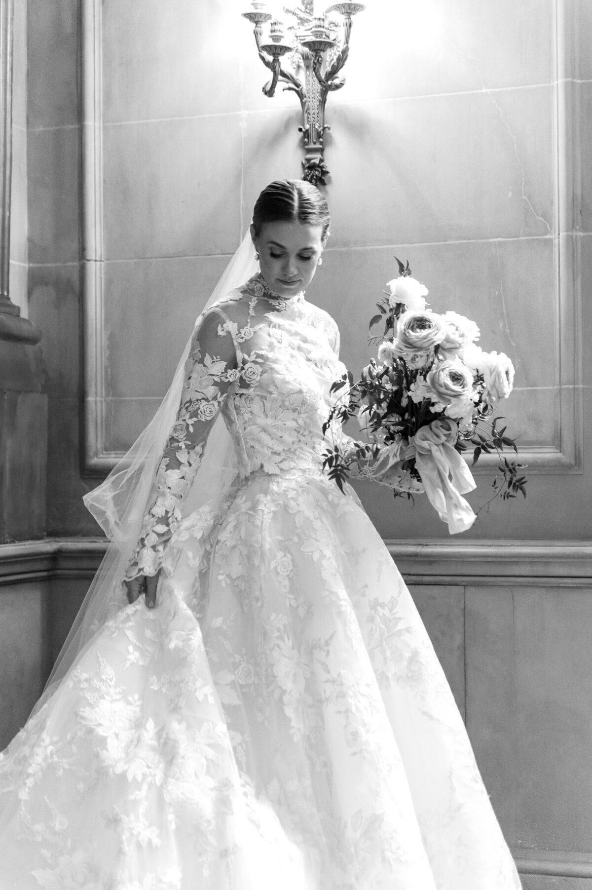 black and white picture of bride adjusting her dress