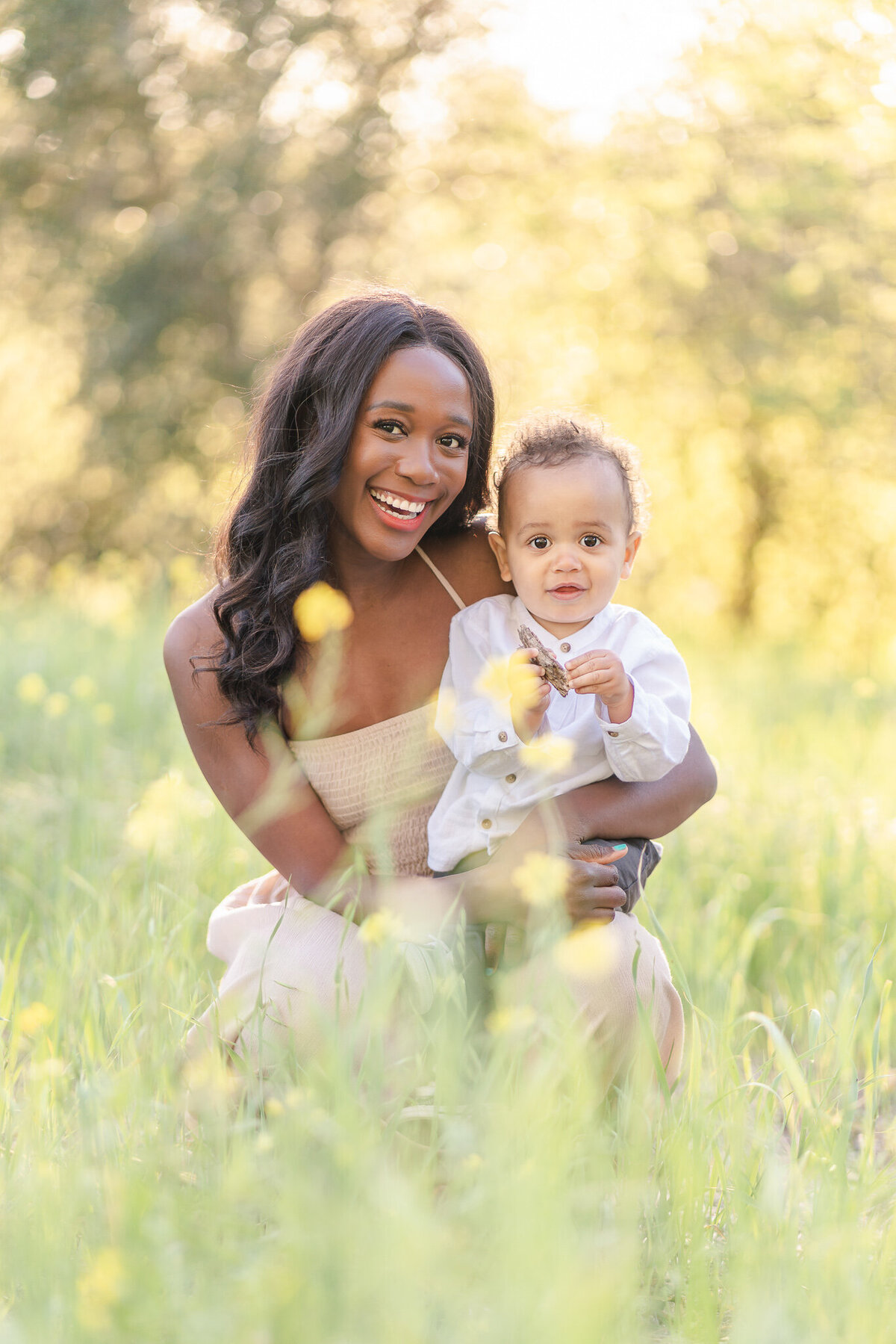 mom holding her son in a field of mustard flower in the san francisco bay area