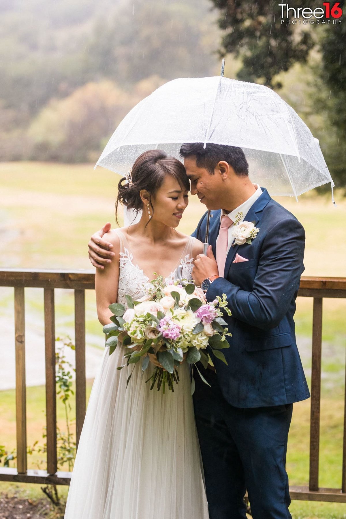 Bride and Groom share a quiet moment together under an umbrella due to rain