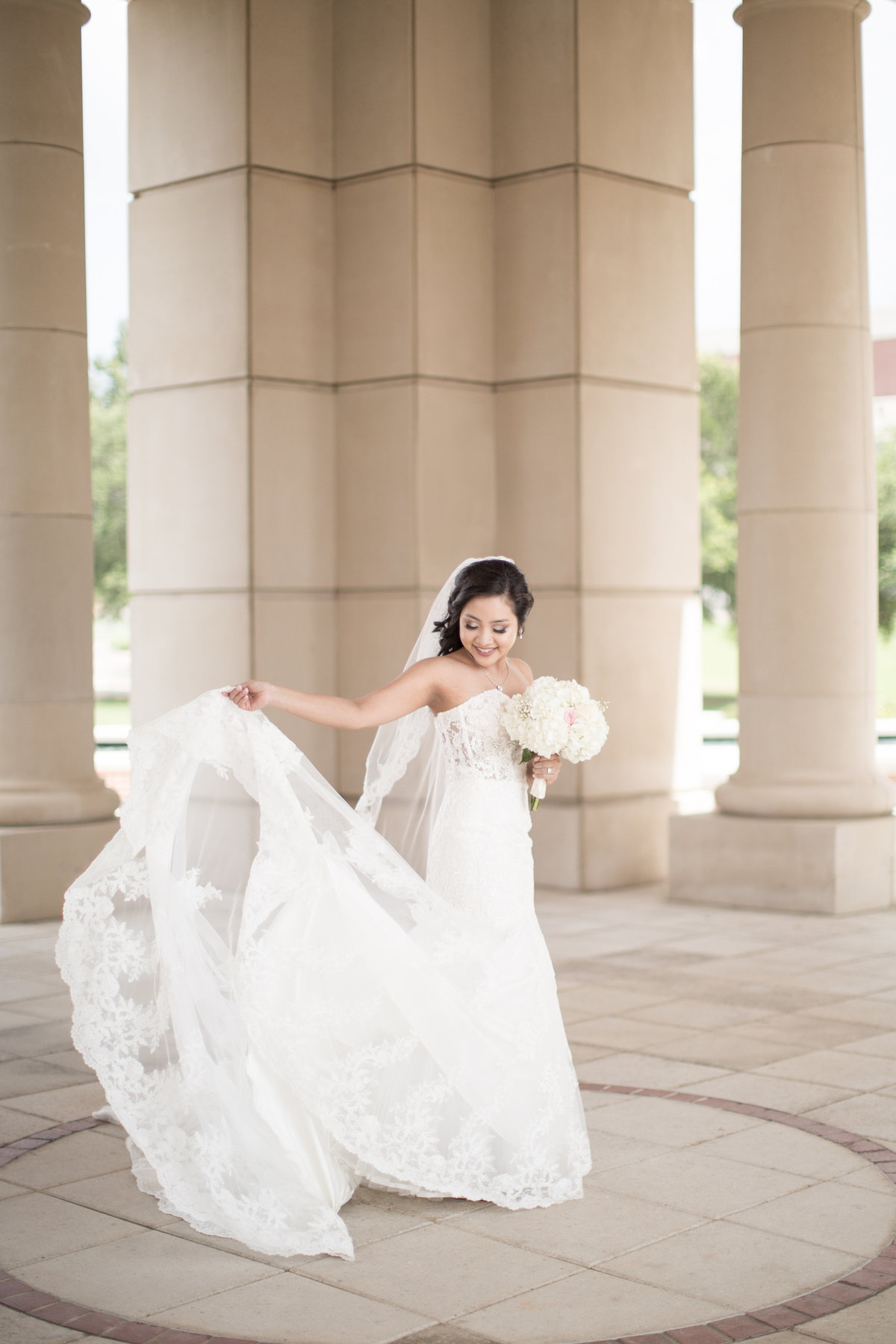 A bride twirls and watches her dress at The Moulton Bell Tower on the campus of The University of South Alabama in Mobile, Alabama.