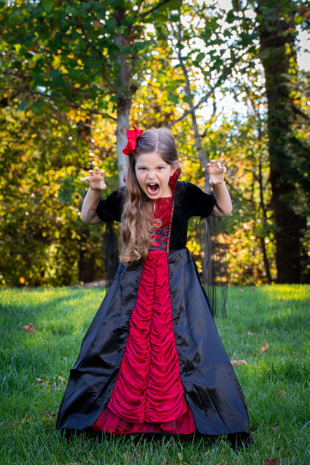 My daughter dressed up as a vampire for Halloween, posing in the woods.