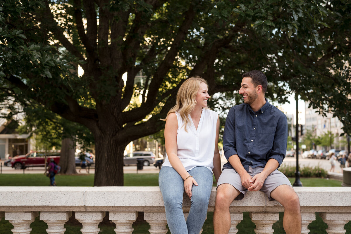 Couple laughing together while sitting on Capitol Square in Madison, WI