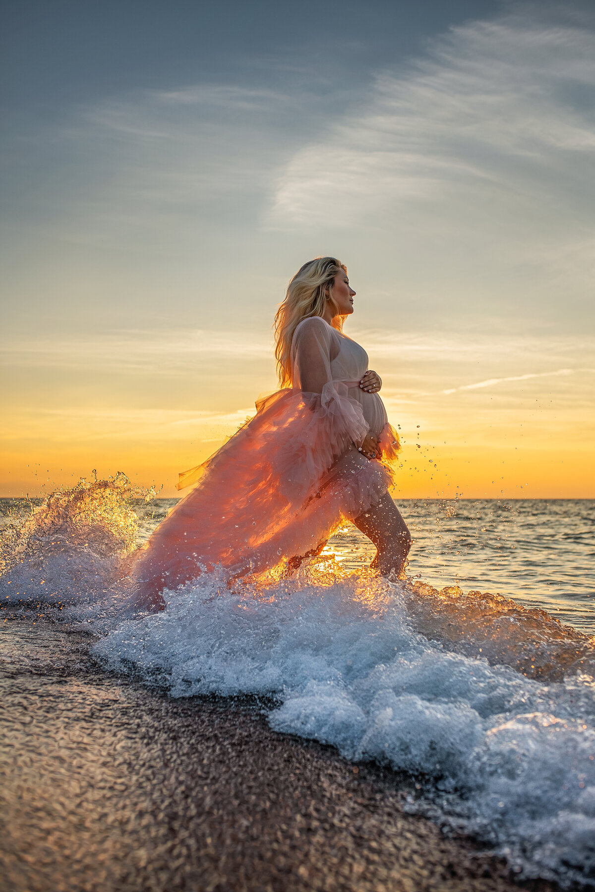 Maternity pictures of pregnant  mom at the beach during golden hour in Lake Michigan  waves