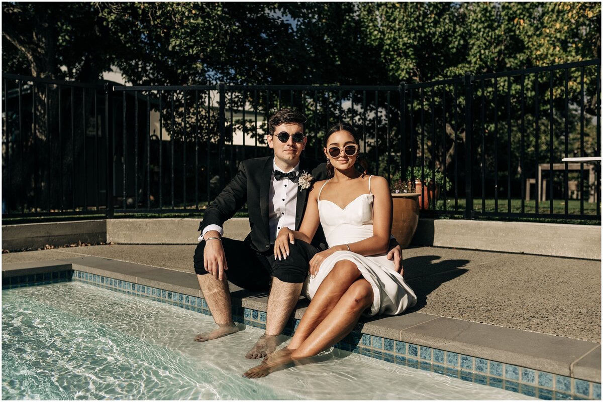 editorial style wedding photo bride groom sitting by pool hot summer day high fashion new zealand in clyde