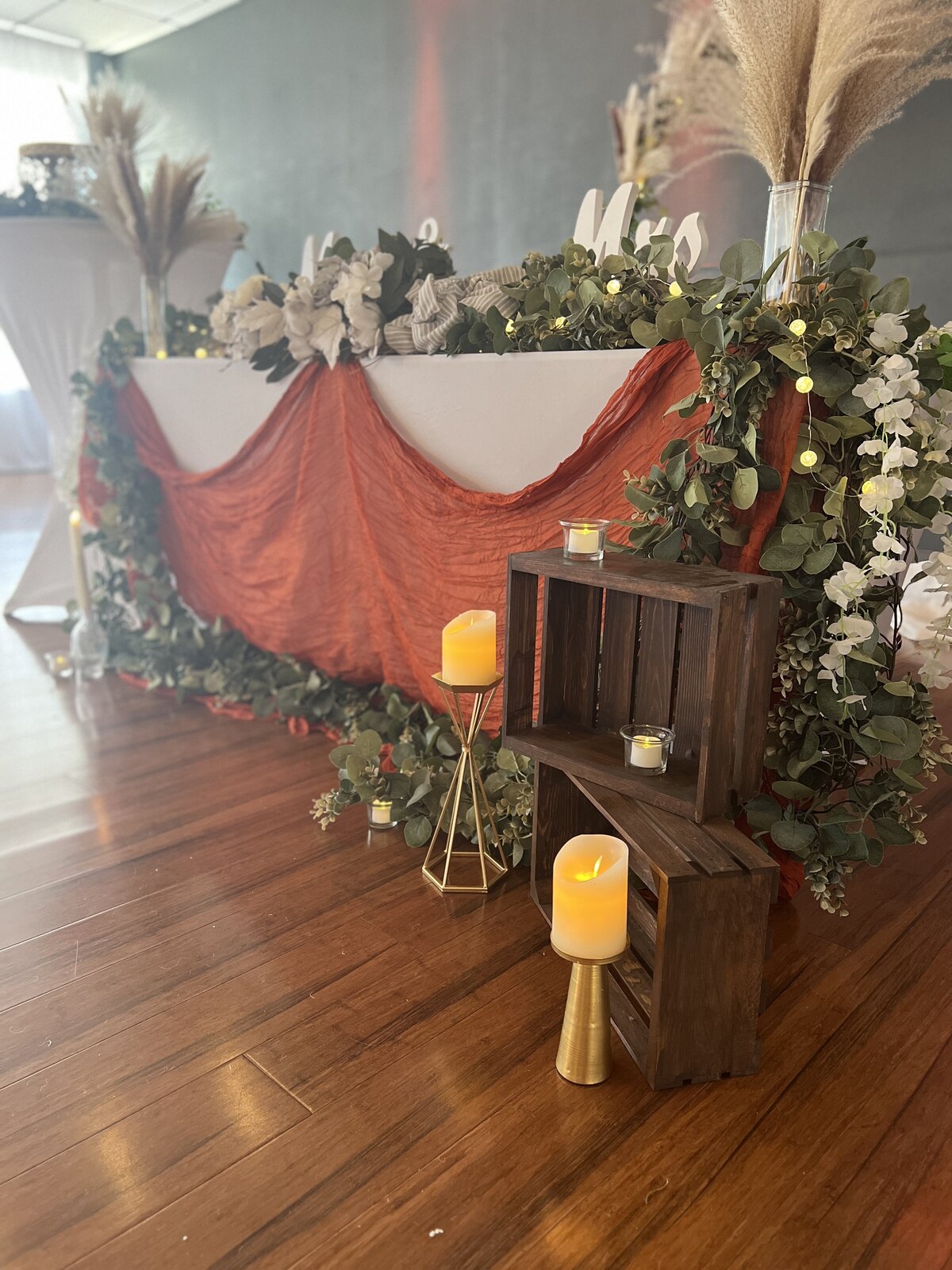 Wedding reception sweetheart table adorned in our natural boho design, part of our affordable decor packages - Customizable colors, boho centerpieces, and LED candles create a romantic ambiance