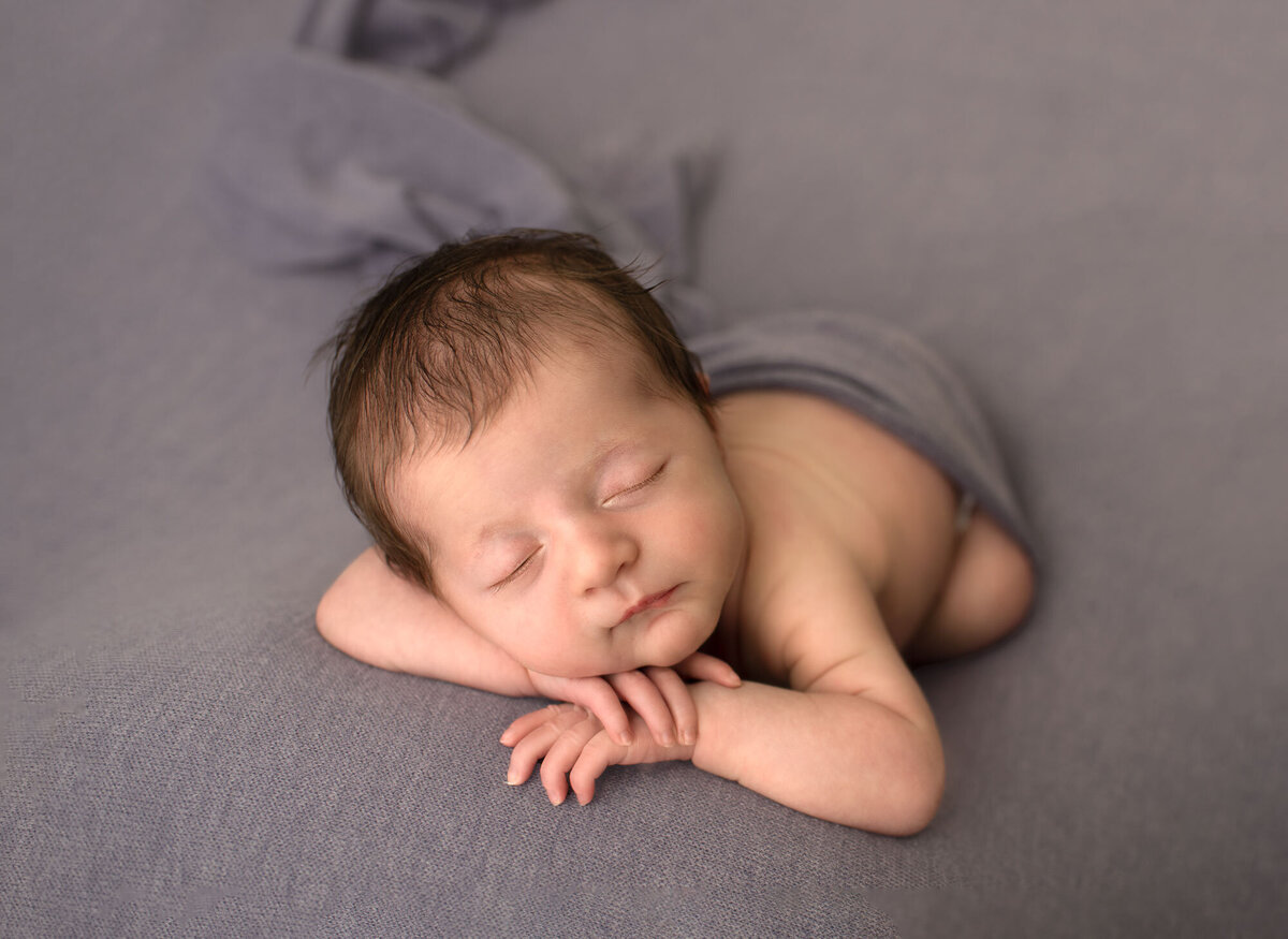 newborn with head on hands by sutherland photography, a saint louis newborn photographer