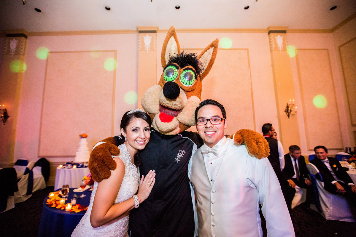 bride and groom pose with San Antonio Spurs coyote at wedding reception at Sheraton Gunter Hotel down town