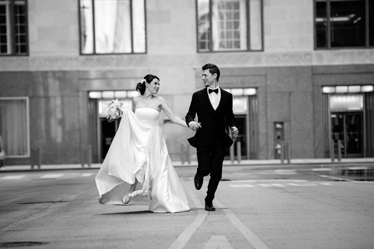 Black and white picture of husband and wife running in the  La Salle  street