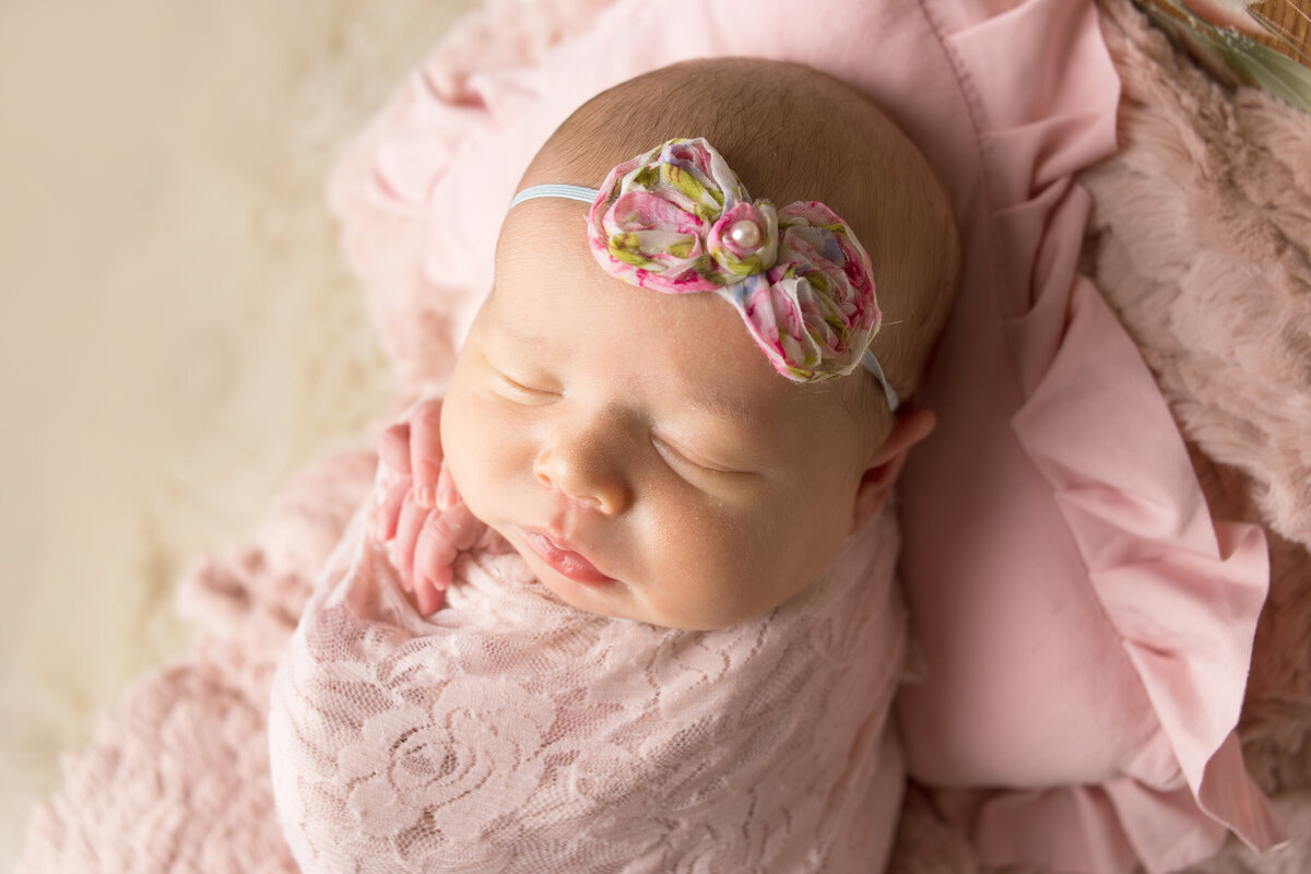 Newborn baby girl sleeping in basket during newborn photoshoot in Mount Juliet tennessee photography studio