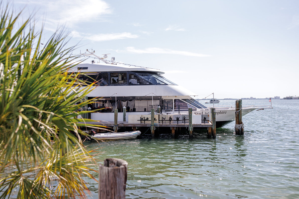 Intimate yacht wedding reception with elegant white flowers, candles, and coastal-inspired décor in St. Petersburg, Florida.