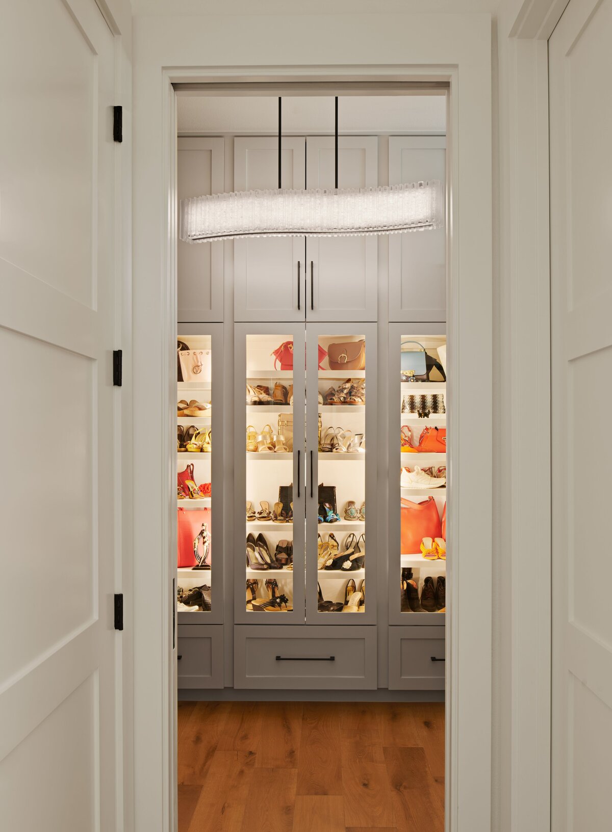 walk in closet with custom shoe shelves and special closet lighting in modern home in austin, texas