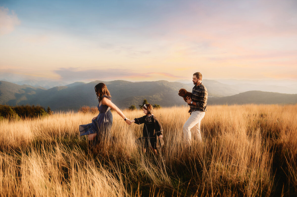Family walks across a mountain top on the Blue Ridge Parkway during their Family Photoshoot in Asheville, NC.
