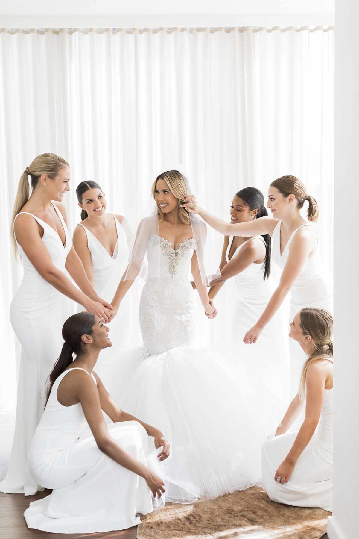 A beautiful and happy bride surrounded by her maids