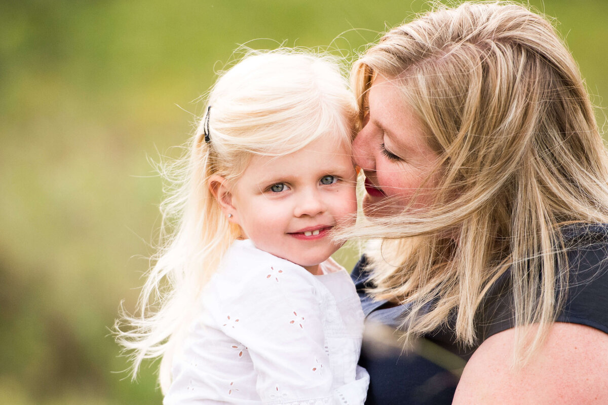 a mom hugs her toddler during Ottawa family photography session