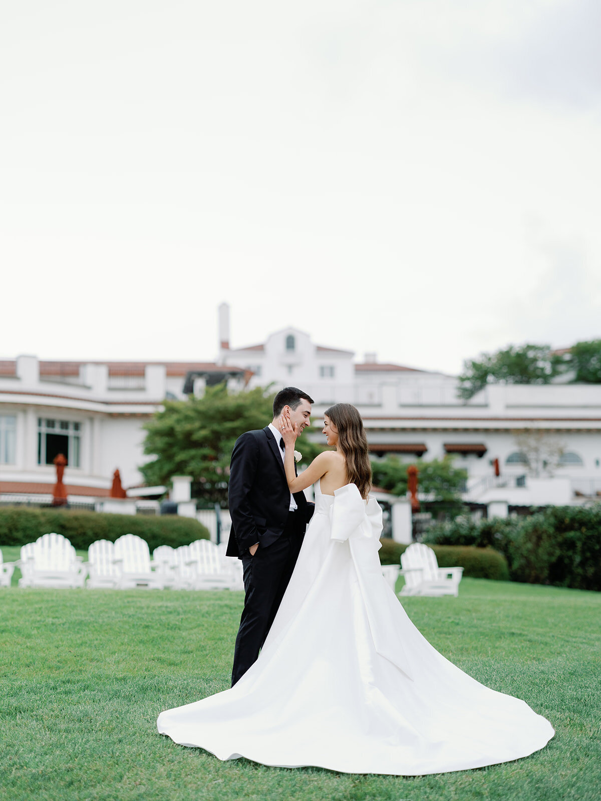 Bride and groom pose in front of congressional country club in bethesda maryland
