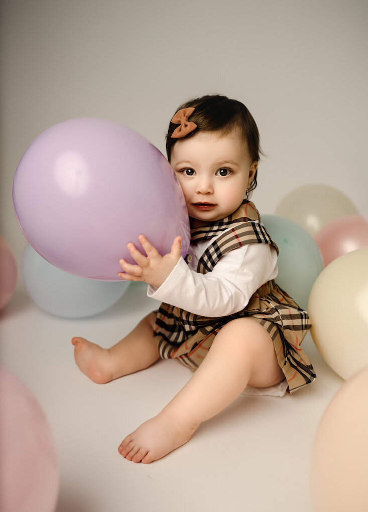 Baby girl turns one holding balloon by for the love of photography Grand rapids