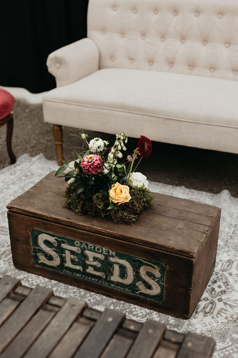 Vintage wedding lounge and trunk with jewel toned flowers.