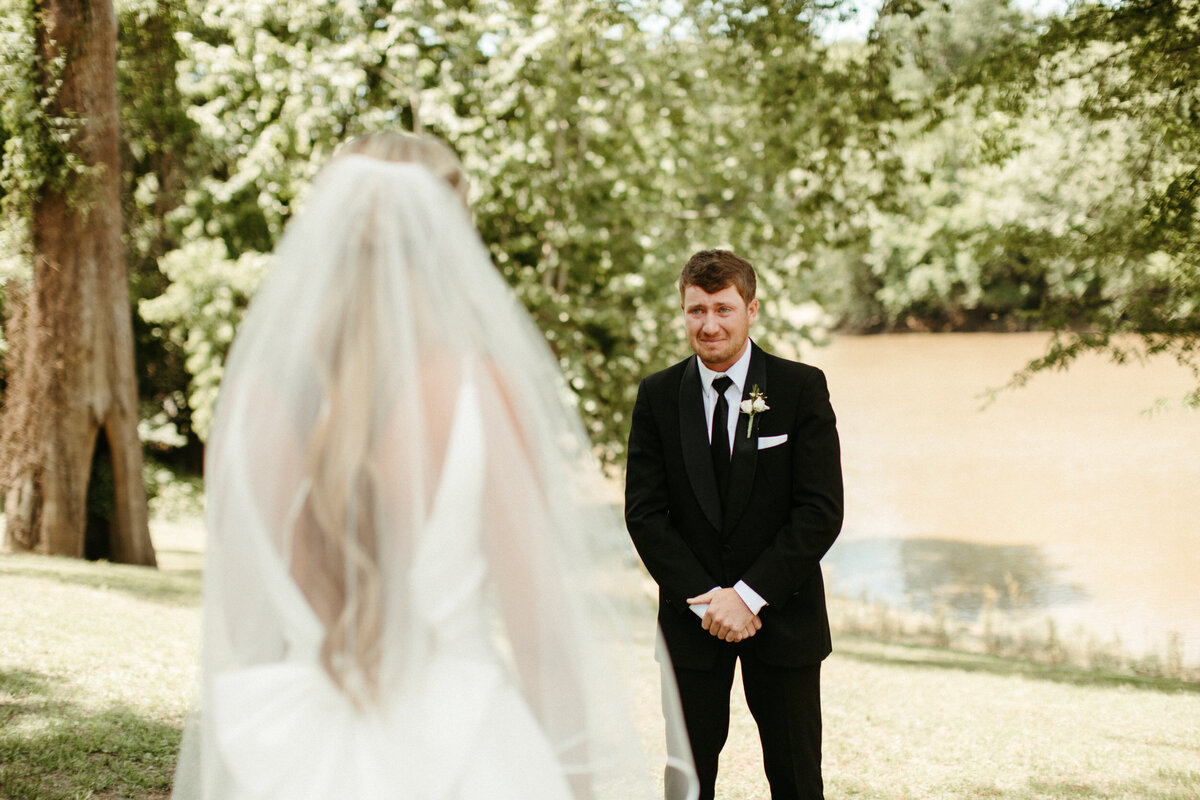 Groom having an emotional reaction to seeing his bride during their first look on their wedding day