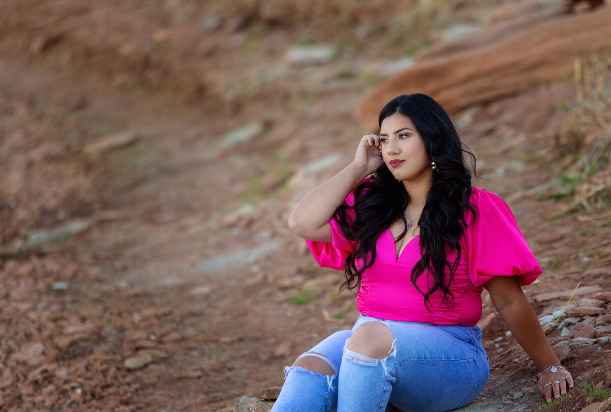 Senior girl sitting on the rocks at Lake mackenzie in a pink shirt & jeans