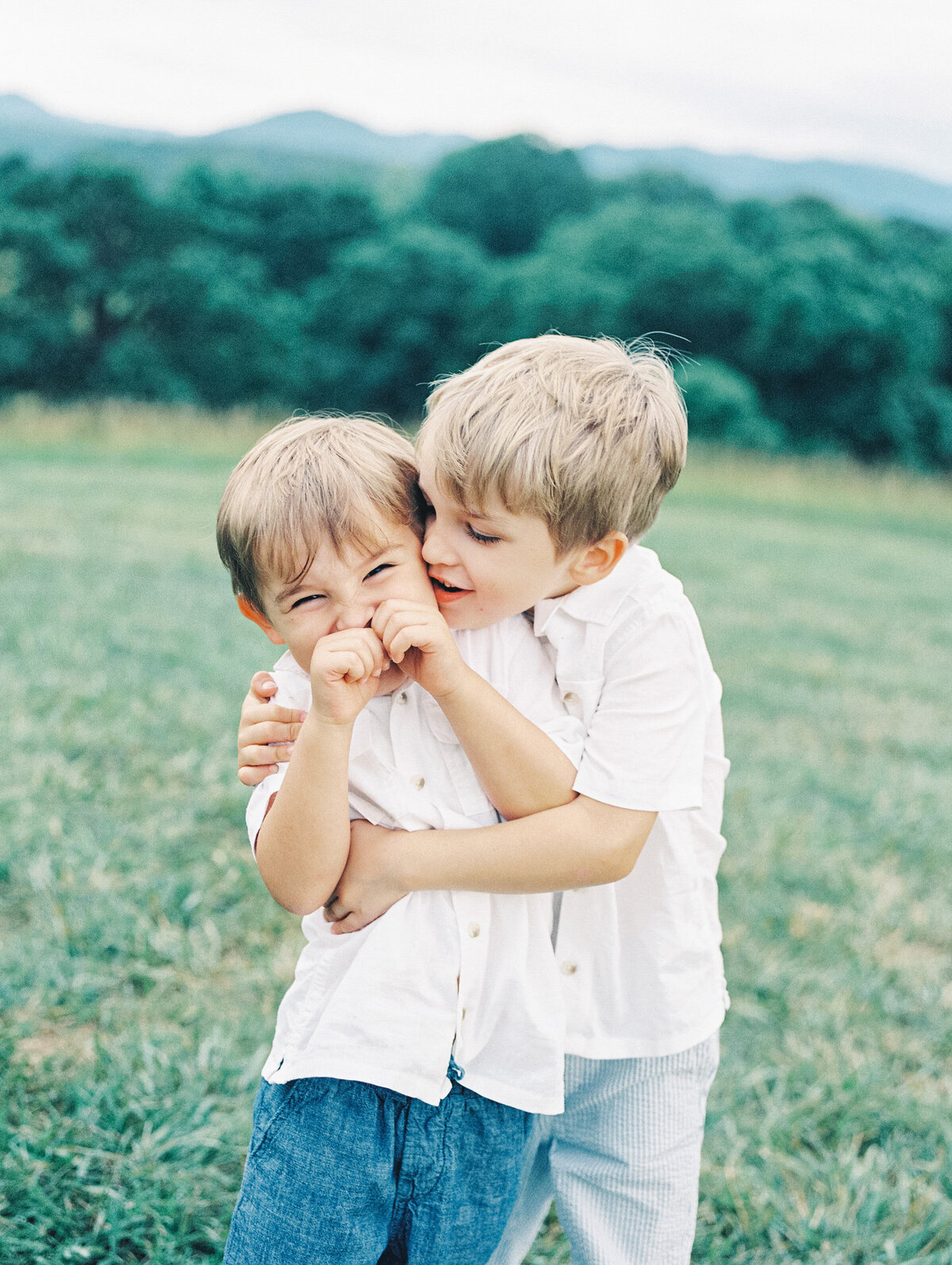 two brothers laughing and hugging outside