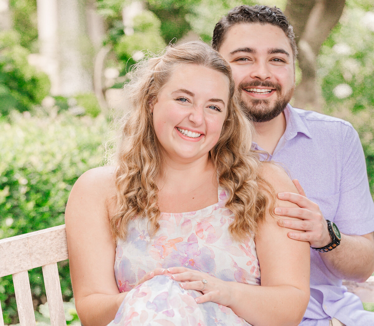 An engaged couple on a Raleigh park bench in the summertime enjoying their North Carolina wedding photos