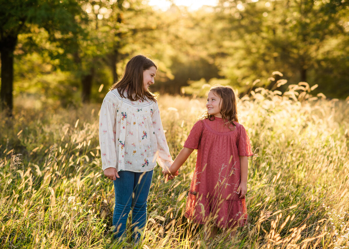 Des-Moines-Iowa-Family-Photographer-Theresa-Schumacher-Photography-Golden-Hour-Grass-Sisters-Holding-Hands