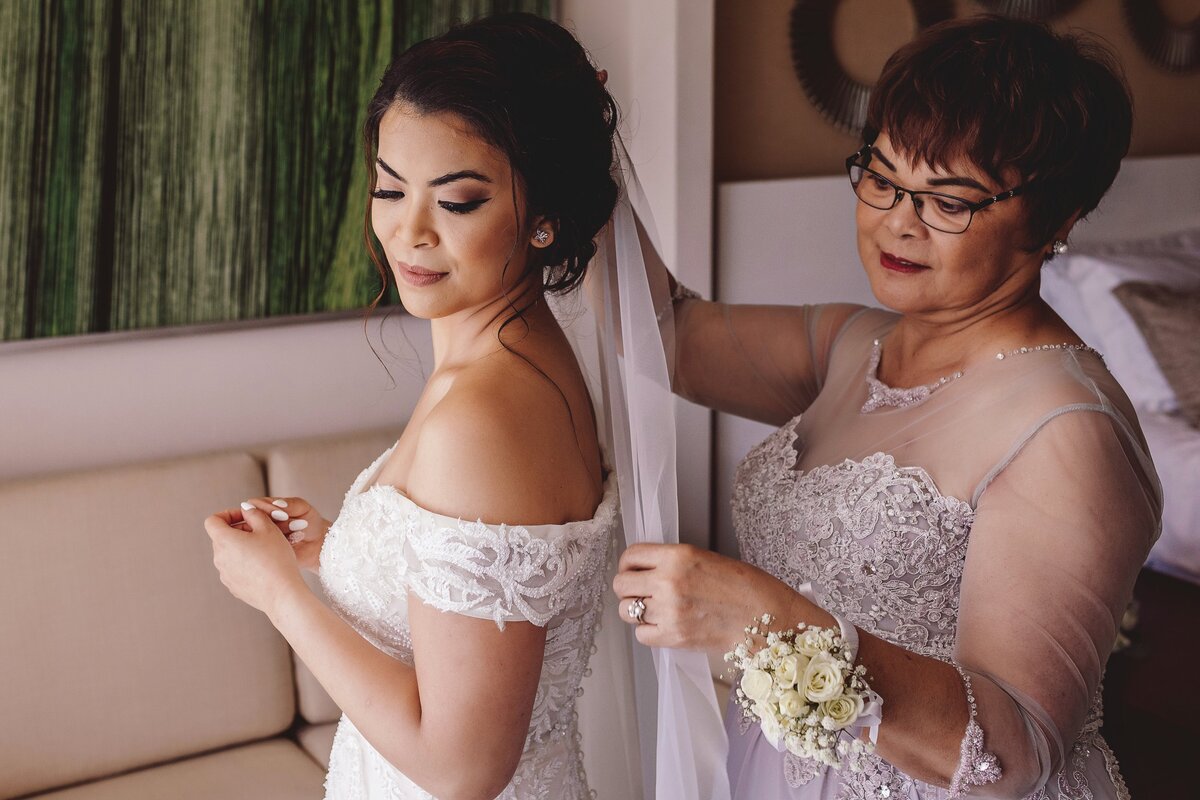 Mother helping bride with veil at Cancun wedding