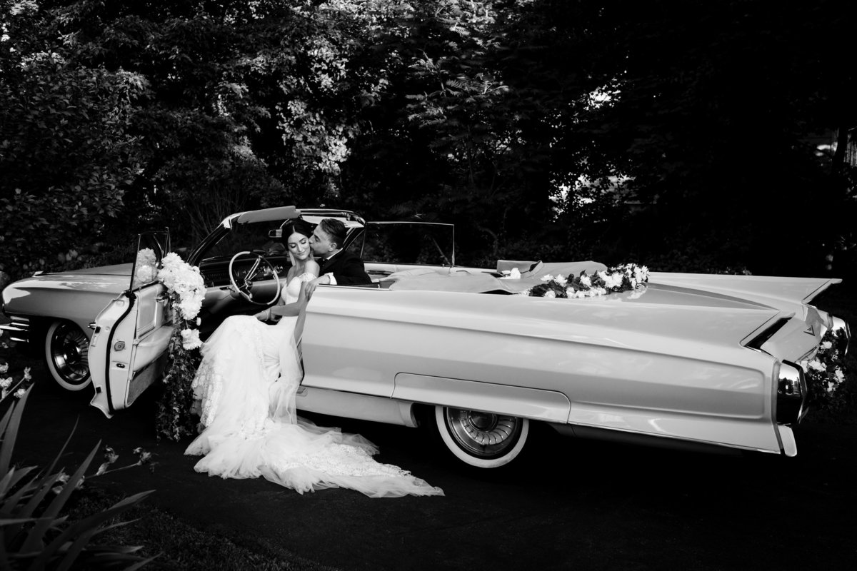 Peabody Essex Museum wedding the bride and groom sit close together in a vintage car after their Greek Orthodox ceremony in Boston