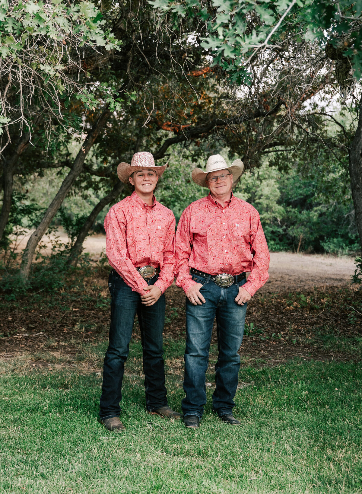 Two cowboys pose together.