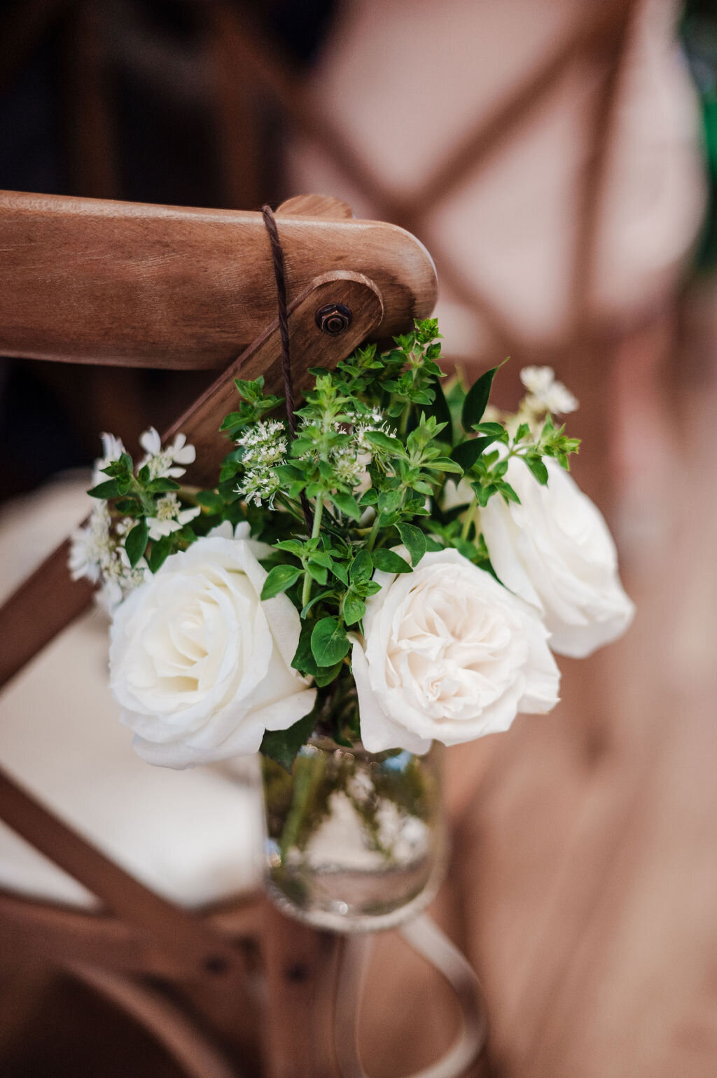 Ceremony decor along the aisle with white roses and fresh summer herbs