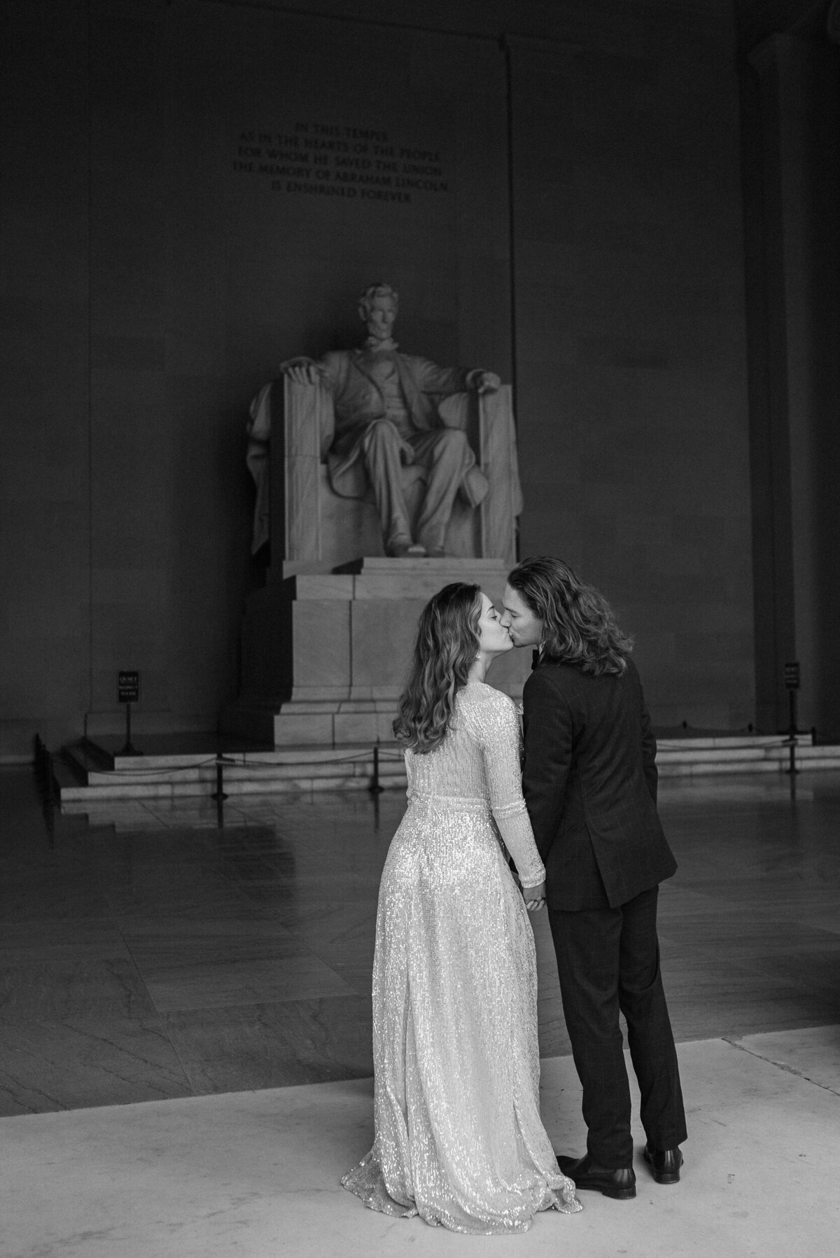 bride and groom standing in front of statue of Lincoln kissing fine art wedding photography washington dc
