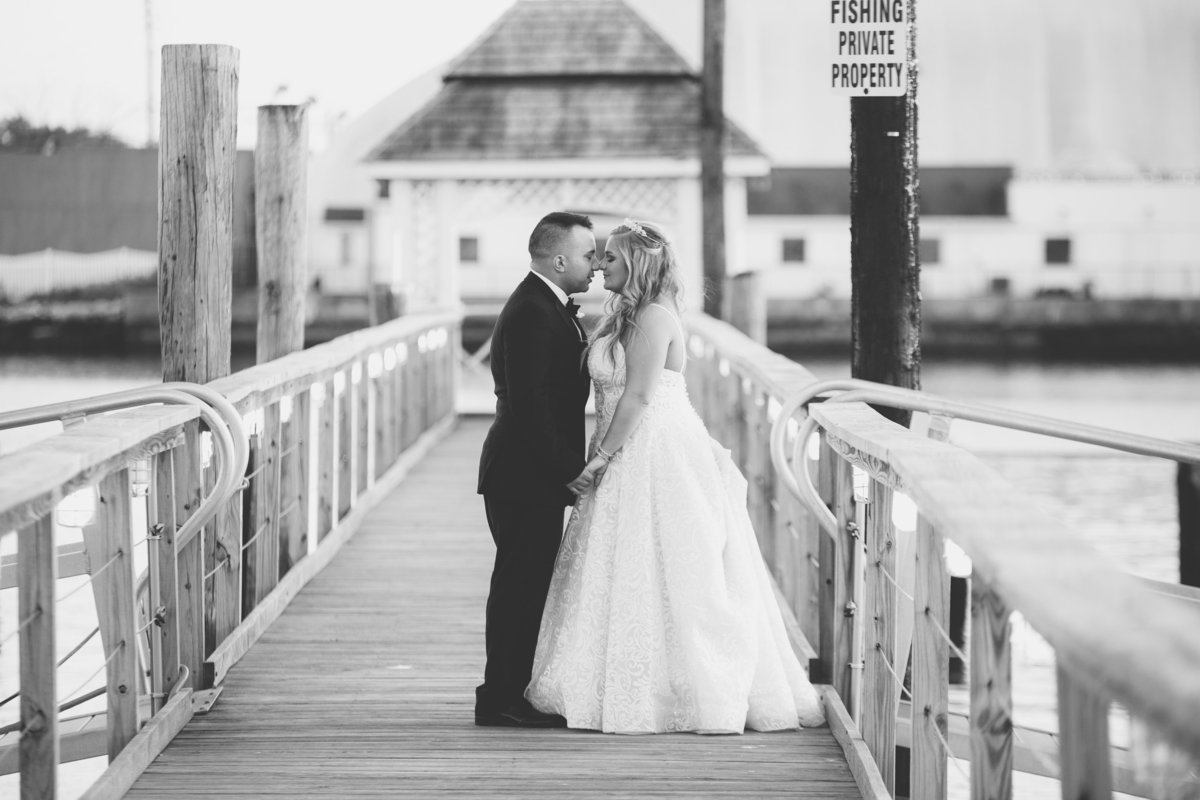 bride and groom kissing on boardwalk at Bridgeview Yacht Club