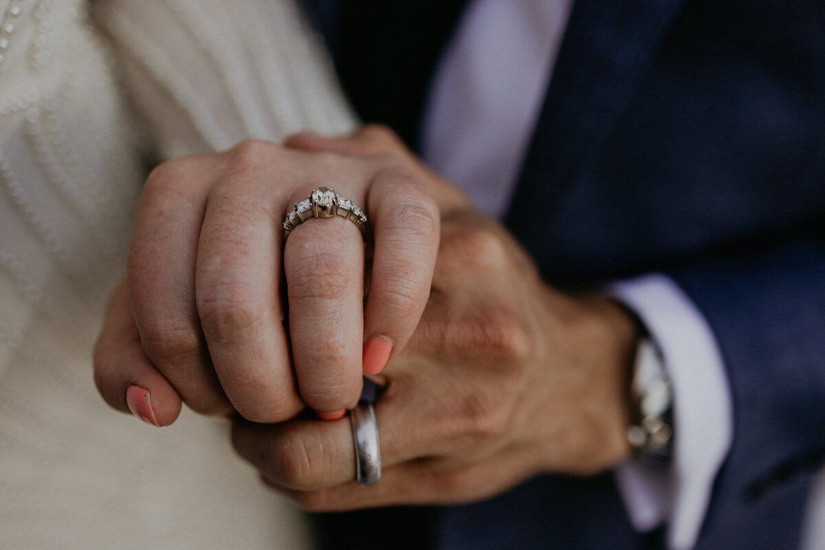 close up of bride and grooms hands with their rings