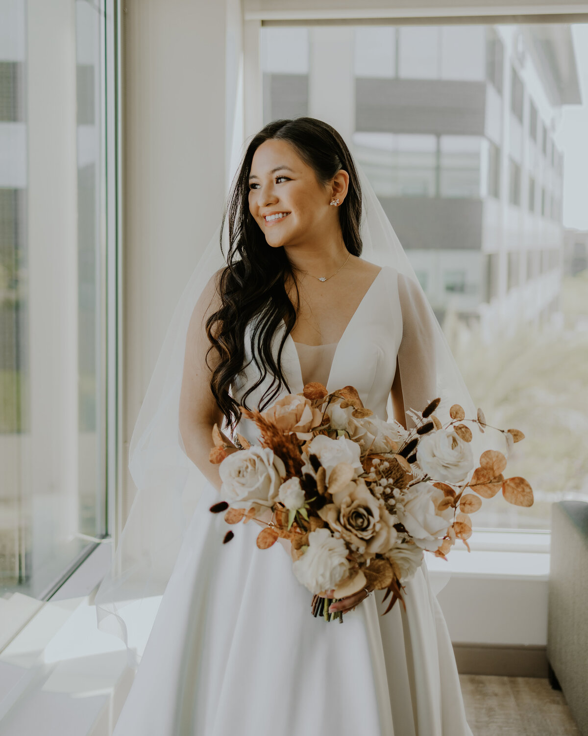 Bride looking out the window with beautiful autumn boho flower bouquet Temecula, California Wedding photographer Yescphotography