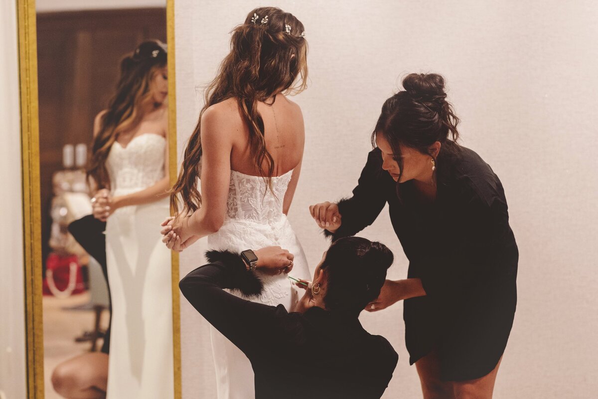 Bridesmaids helping bride into dress for Cancun Wedding