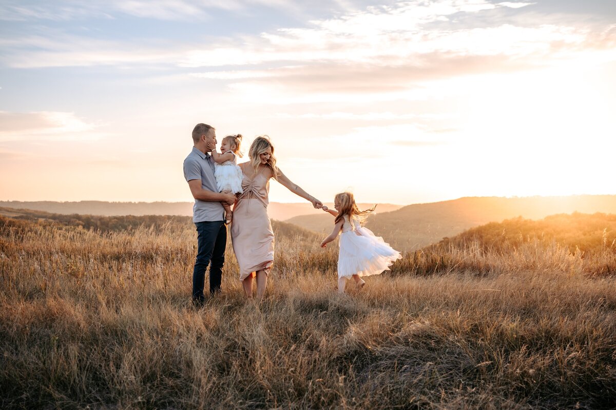 North Dakota family twirling on hilltop at sunset