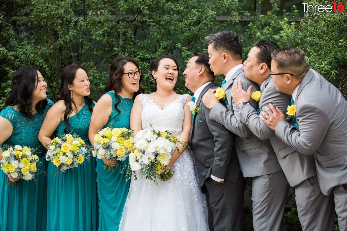 Bridal party laugh it up as they encourage the Bride and Groom to kiss