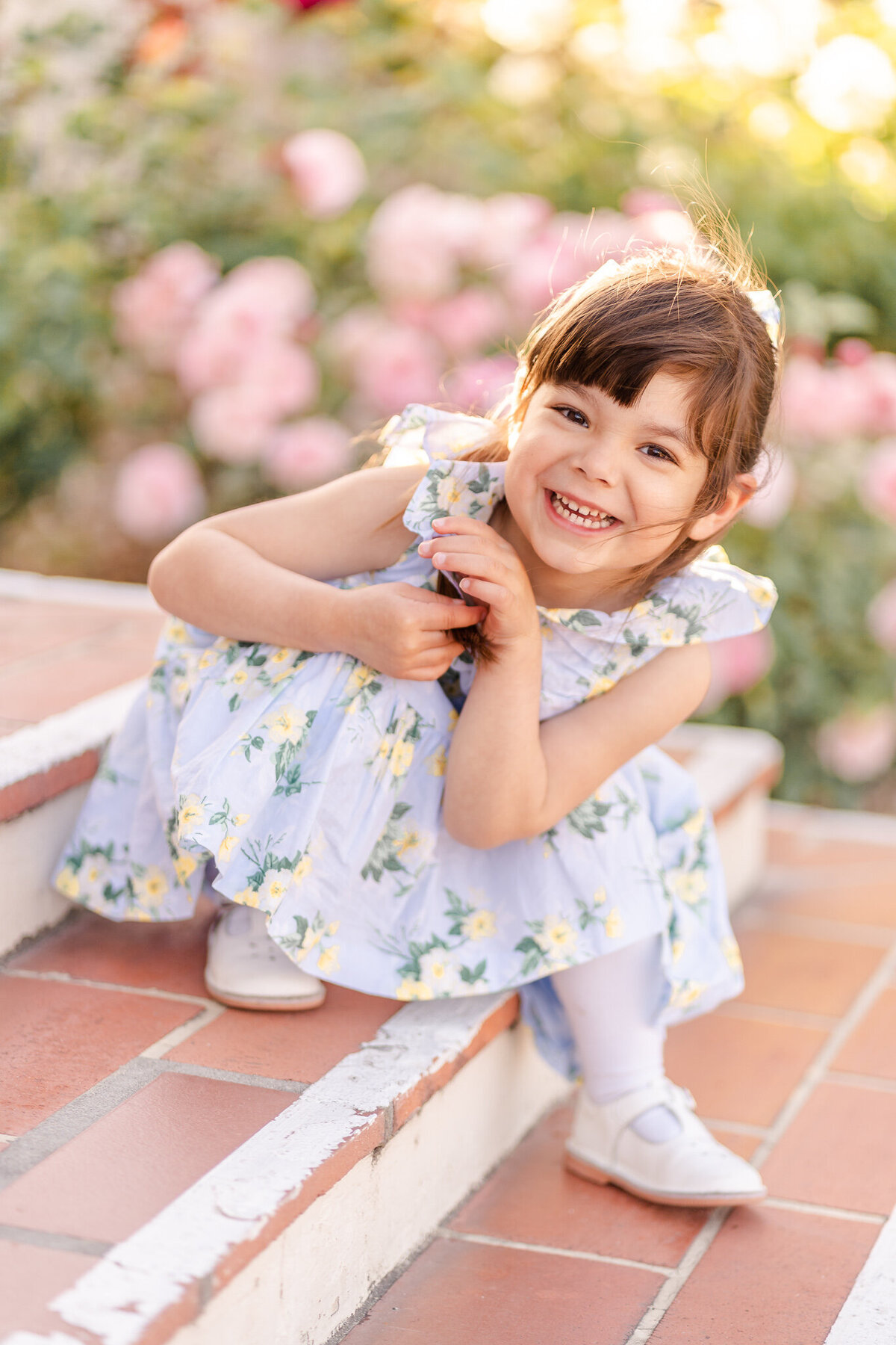 bay area family photography closeup of little girl  in a floral dress smiling at the camera