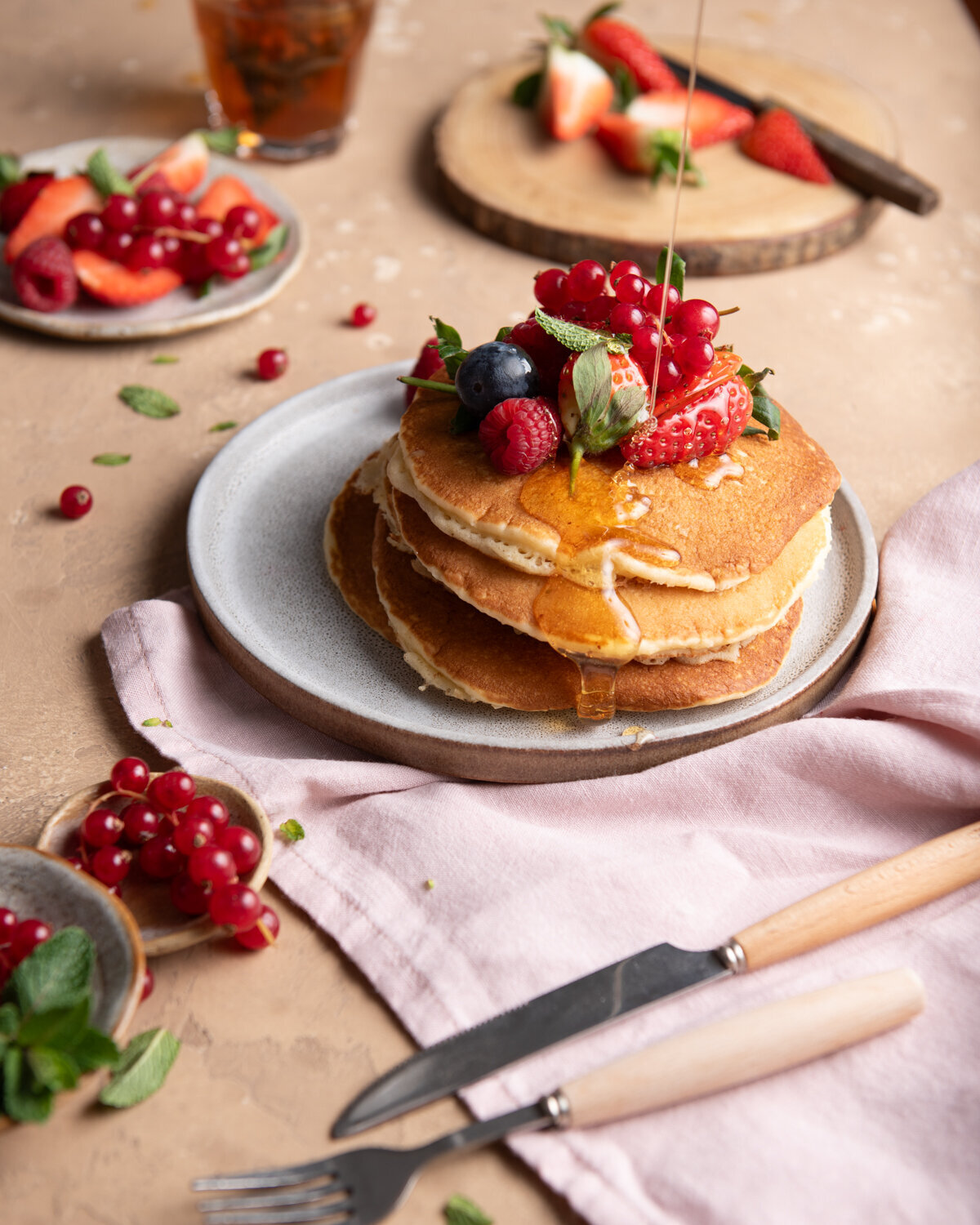 Omayah Atassi Dubai Food Photographer and Food Stylist Stack of Pancakes Topped with Fruit and Being Drizzled with Syrup