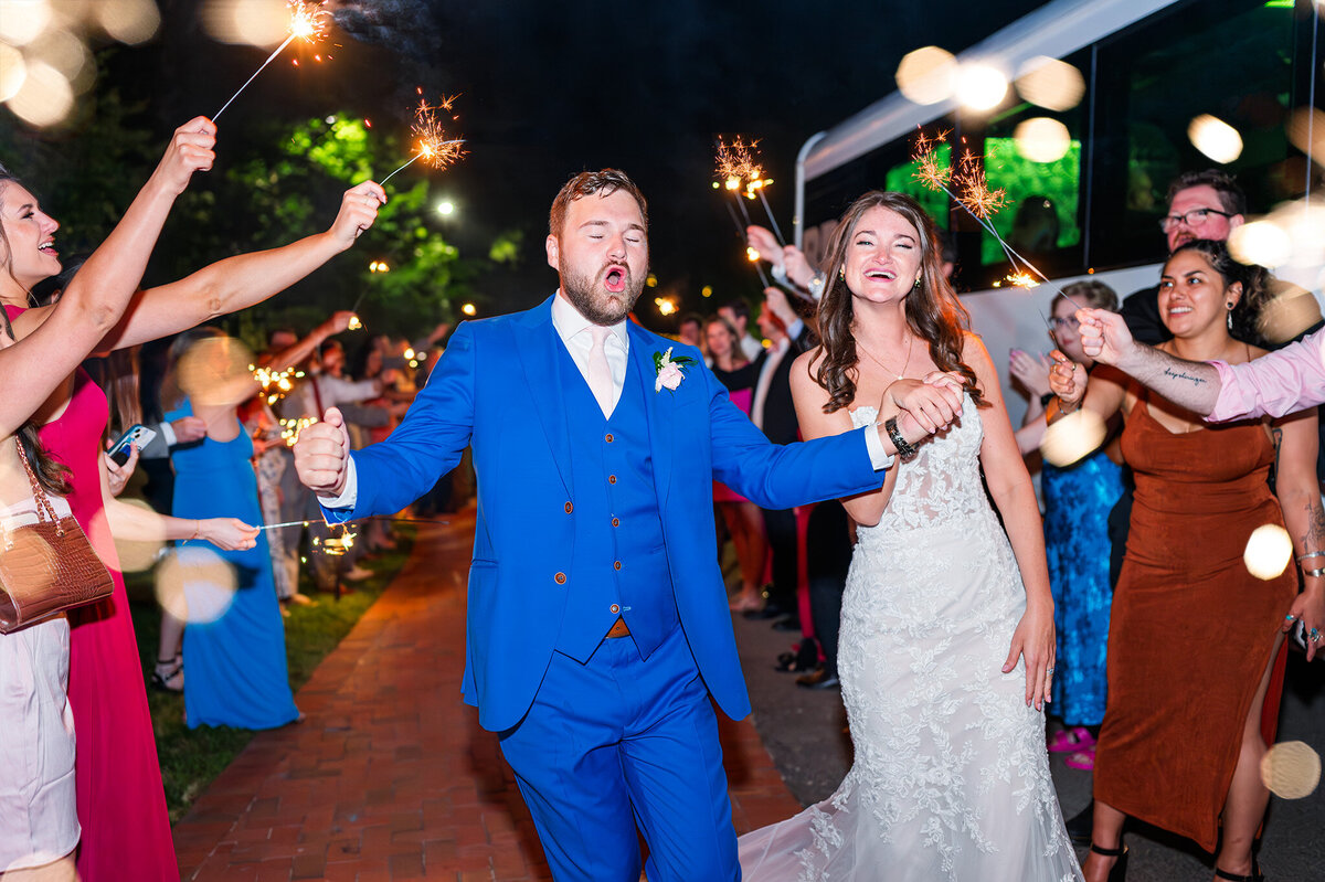 A newly married couple leaving their wedding at The Angus barn during their sparkler exit at their reception by JoLynn Photography, a Raleigh wedding photographer