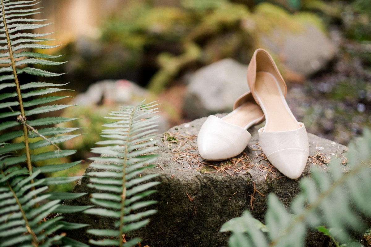 bridal slipon shoes on a rock among ferns
